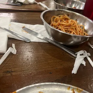 Spaghetti severed in tin animal feeding bowls .