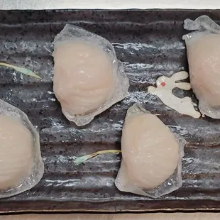 four pieces of raw fish on a tray