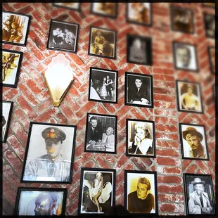 a brick wall with a lot of pictures on it