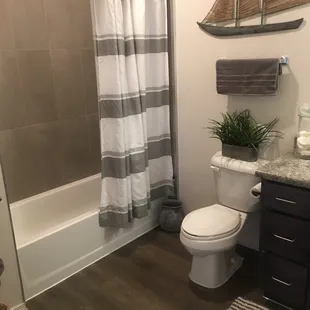 Bathroom with easy to step in shower, tile walls &amp; curtain rod.
