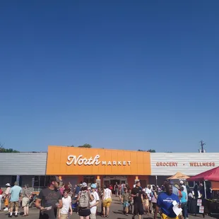 a large crowd of people standing in front of a store