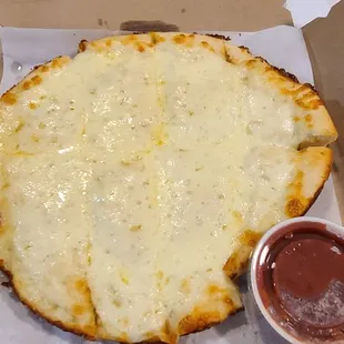 Pizza fries with a side of sauce.