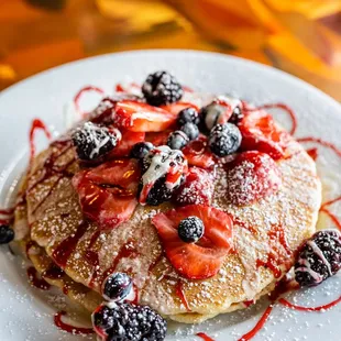 a stack of pancakes topped with berries