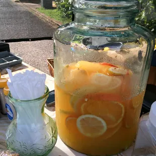 a glass jar of lemonade and a pitcher of sugar