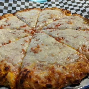 a cheesy pizza on a checkered plate