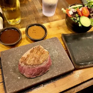 Seared steak on a stone. And house salad.
