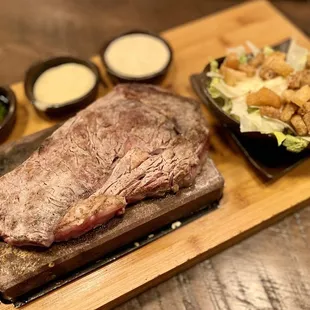 Delmonico steak on a stone with Caesar salad