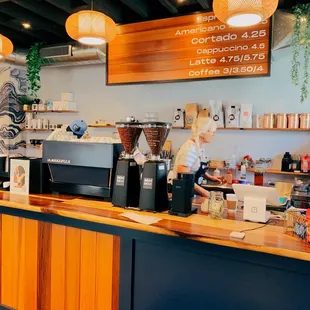 a coffee shop counter with a sign above it