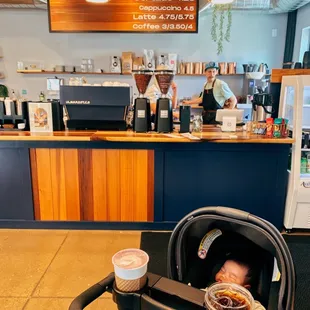 a baby in a stroller at a coffee shop
