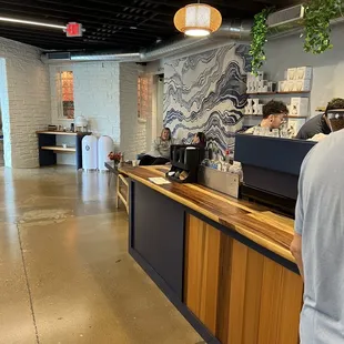 a man standing at a counter in a coffee shop
