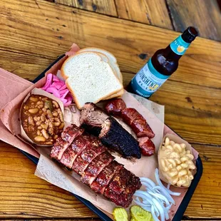 barbecue platter with ribs, beans, pickles, and beer
