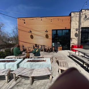 a view of a patio with tables and benches