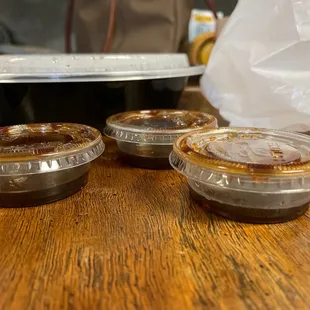 three takeout containers on a wooden table