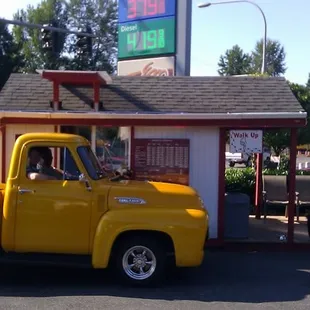 a yellow truck parked in front of a restaurant