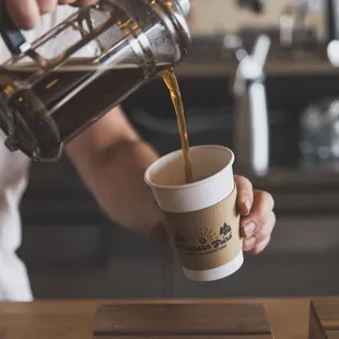 a person pouring a cup of coffee