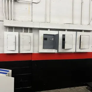 Fuse boxes not really closed along walkway behind seating.