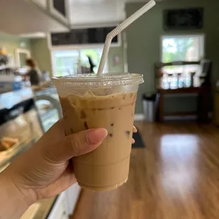 a hand holding a cup of iced coffee