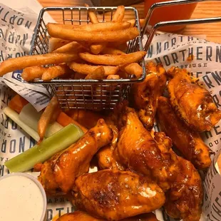 a basket of chicken wings and french fries
