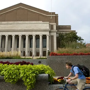 a man riding a bike in front of a building