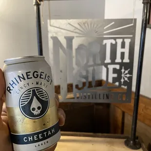 a hand holding a can of beer