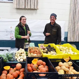 two people standing in front of produce
