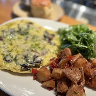 an omelet, potatoes, and greens