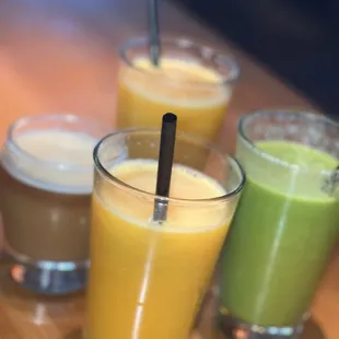 three glasses of juices on a table