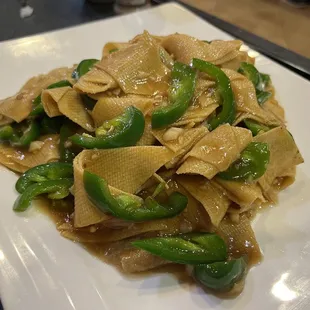 a plate of noodles and green peppers