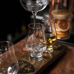 a person pouring a glass of whiskey