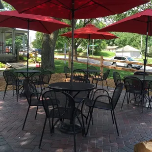 tables and chairs under umbrellas