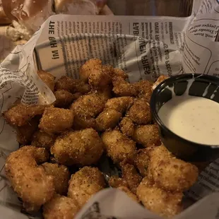 a basket of fried tater tots with dipping sauce