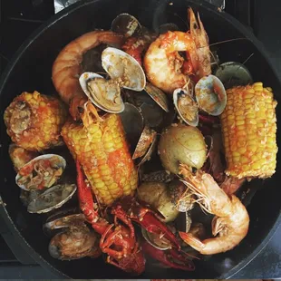 a pot full of seafood and corn