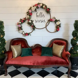 a red velvet couch with gold pillows