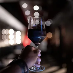 a hand holding a glass of wine