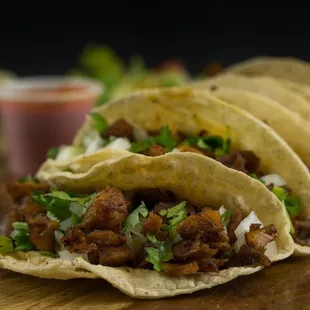three tacos on a cutting board