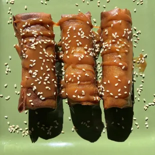 Turon( Banana egg rolls) deep fried and drizzled with roasted sesame seeds and caramel syrup.  $5.75/ 3 pcs