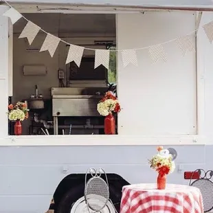 a food truck with a table and chairs