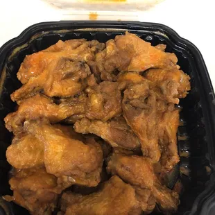 a close up of a container of chicken wings