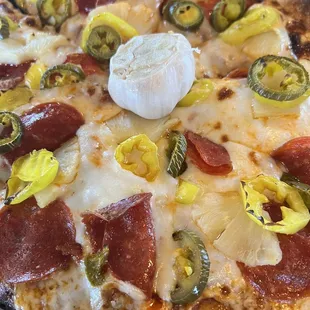 a pizza with pepperoni, jalapenos, and cheese