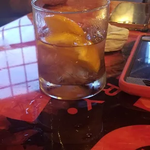 a glass of water with ice and an orange slice