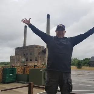 a man standing in front of a factory