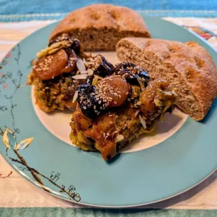 Baked chicken with prunes, apricots, and almonds served with Moroccan bread