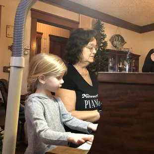 A mother delights at her daughter's spontaneous  response on the piano with the composer, Julie Guile