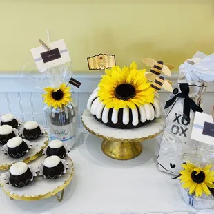 a table with sunflowers and cupcakes