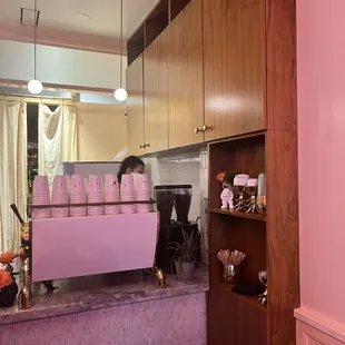 a woman behind the counter of a coffee shop
