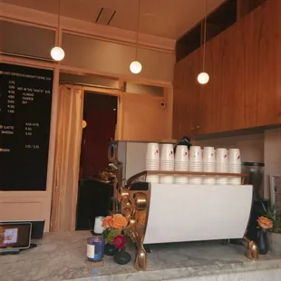 a coffee shop counter with cups on it