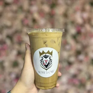 a hand holding a cup of iced coffee