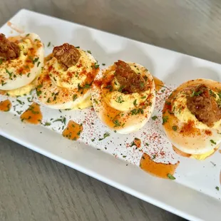 Deviled eggs garnished with a tiny piece of chicken