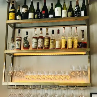 a shelf of wine glasses and bottles