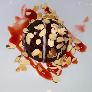 a desert with chocolate and almonds on a white plate